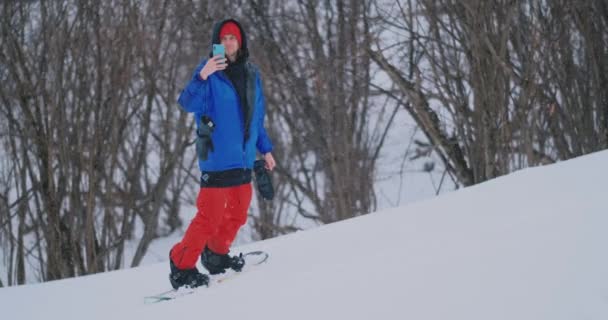 あなたのスマート フォンを使用して、スキー場でスノーボードしながら風景の写真を撮る — ストック動画