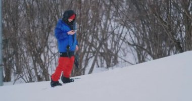 Erkek snowboard kar yamaç ve Smartphone-e doğru senin sokulgan için yazmak için yönetim kurulu Kayak rides