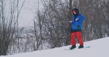 Smartphone üzerinde kayak pisti snowboard yaparken manzara resimlerini çekmek için kullanın