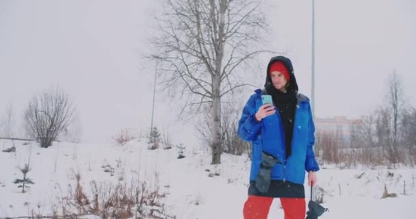 Αργή κίνηση πυροβολισμό του ένας snowboarder χρησιμοποιώντας ένα smartphone κατά την οδήγηση σε μια πίστα σκι — Αρχείο Βίντεο