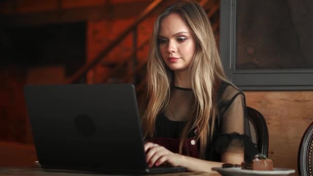 Happy young woman drinking coffee and using tablet computer in cafe — Stock Video