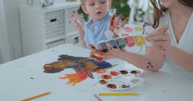 İki çocuk annesi ve erkek geliştirme ödev yapmak yaratıcı kağıt üzerinde parmak tarafından nişanlandık. Dokunsal hissi ve küçük matematik geliştirilmesi.