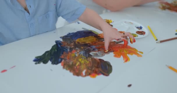 Nahaufnahme Kinder zeichnen ihre Finger mit Farben auf Papier — Stockvideo