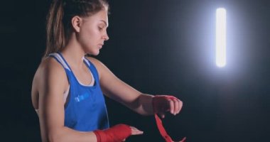Güzel bir kadın boksör vurdu Orta kırmızı bandaj bir kadın savaşçı bilek üzerine çeker. steadicam vurdu