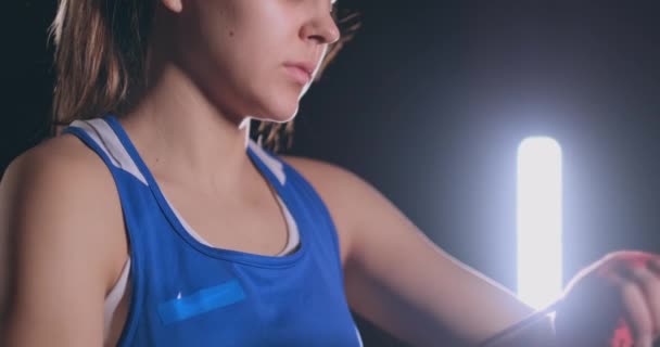 Il primo piano di una bella pugile atletica tira bende rosse sulle mani di una combattente donna. steadicam shot — Video Stock