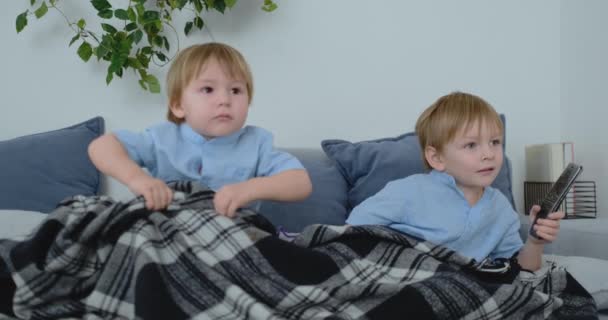 Deux enfants regardent une émission de télévision passionnante à la télévision. Deux frères regardent la télé — Video