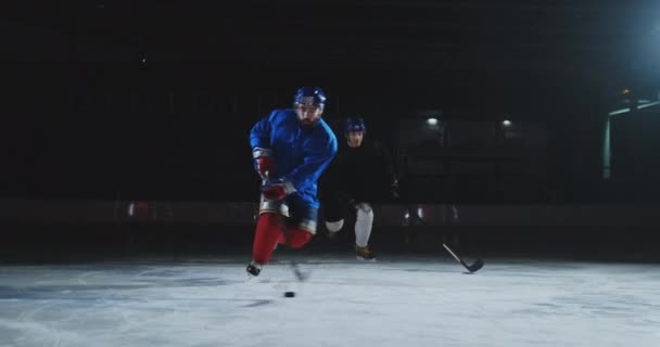 Két ember játék hokizni a jégpálya. Két Hockey Jégkorong játékos, korong. Steadicamnél lövés — Stock videók