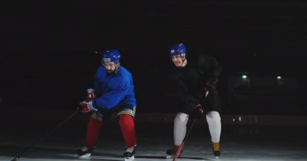 Zwei Männer spielen Eishockey auf der Eisbahn. Hockey zwei Hockeyspieler kämpfen um den Puck. Steadicam-Aufnahme — Stockvideo