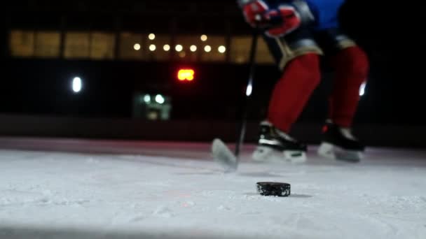 Létající sněhu na ledě a Close-up zpomalené hokejový puk, hokejový brankář nabere PUK holí