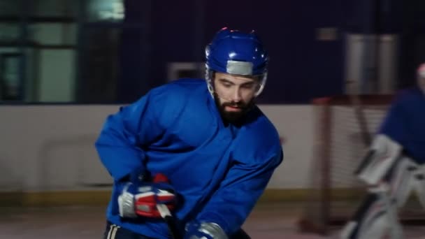 Hockeyspelare utför ett angrepp på motståndare målet och gör mål i extra tid. Spelaren ger segern till hans team i skottlossningar — Stockvideo