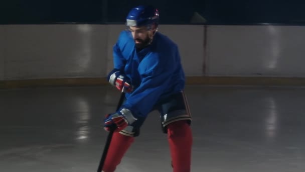 Professionell idrottsman manliga ishockeyspelare vänder framför kameran med en puck och slår motståndarna mål och värderingar — Stockvideo