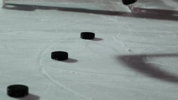 Крупный план шайбы на льду и хоккеист ударяет шайбу в замедленной съемке — стоковое видео