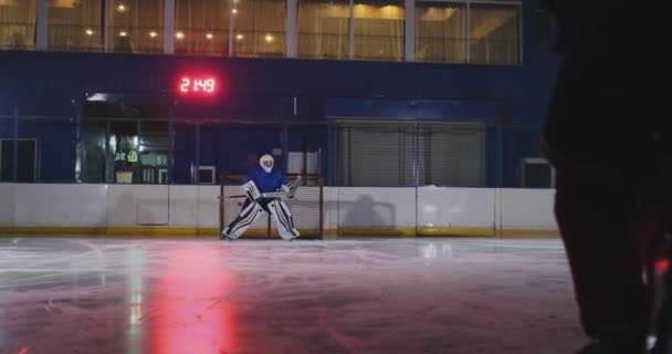 Hockeyspeler voert een aanval op het doel van de tegenstanders en scoort een doelpunt in extra tijd. De speler brengt overwinning voor zijn team in shootouts — Stockvideo