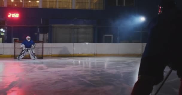 Hockeyspeler voert een aanval op het doel van de tegenstanders. Liggend in een helm vangt de puck en slaat de wedstrijd. Hockey speler man van de wedstrijd — Stockvideo