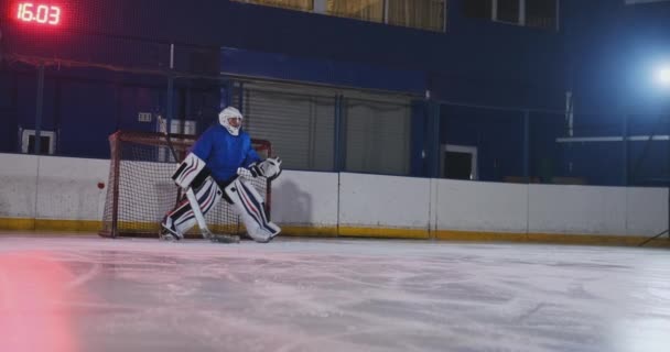 Profesionální hokejový brankář chytí puk po zasažení hráče hokejový zápas