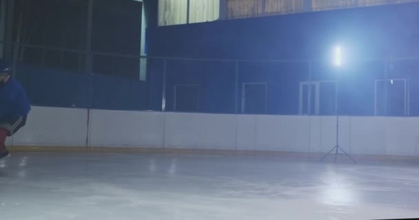 Hockey adelante llevando un disco, patinando más allá de un defensor contrario y tomando una bofetada portero tiro prevenir el marcador de un gol mediante la captura del disco — Vídeo de stock
