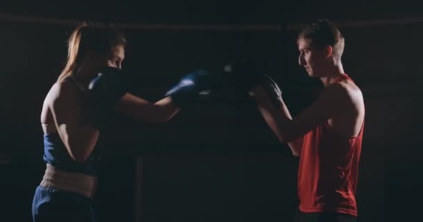 Jovem mulher adulta fazendo treinamento de kickboxing com seu treinador . — Vídeo de Stock