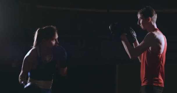 Kickboxer woman athlete kickboxing coach training female fitness friends boxing punching focus mitts enjoying intense exercise workout together in gym close up — Stock Video