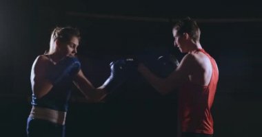 Kadın boksör dumanlı bir spor salonunda boks eldivenli bir odak eldiveni Delme
