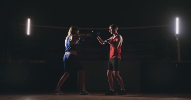 Jeune femme adulte faisant de la kickboxing avec son entraîneur . — Video