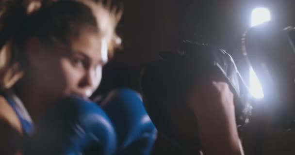 Vacker kickboxning kvinna utbildning stansning fokus vantar i fitness studio hård styrka passar kroppen kickboxer serien — Stockvideo