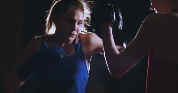 Tiro medio de mujer hermosa fitness boxeador treneruemsya golpear guantes de enfoque de velocidad con un entrenador en un club de boxeo. cámara lenta — Vídeo de stock