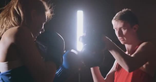 Průměrný střelec krásné fitness žena boxer treneruemsya strike rychlost ostření palčáky s trenérem v boxerském klubu. Zpomalený pohyb — Stock video