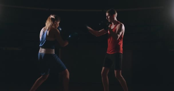 Kickbokser vrouw atleet kickboksen coach opleiding van vrienden van de vrouwelijke fitness boxing bokszak focus mitts genieten van intense oefening workout samen in sportschool close-up — Stockvideo