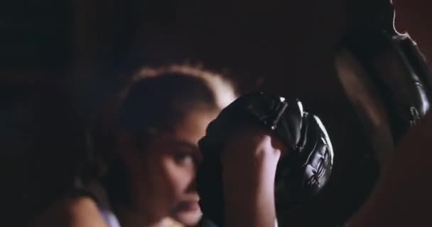 Молода доросла жінка займається кікбоксингом зі своїм тренером . — стокове відео