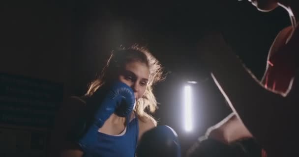 煙のようなジムでボクシング グローブとフォーカス ミットを打つ女性のボクサー — ストック動画