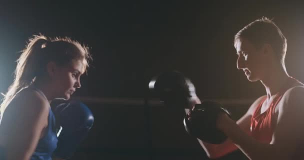Fitness mujer atleta boxeo puñetazos foco guantes disfrutando de ejercicio intenso mujer luchadora entrenamiento amigo en gimnasio entrenamiento juntos cámara lenta — Vídeo de stock