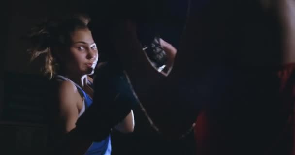 Молодая взрослая женщина занимается кикбоксингом со своим тренером . — стоковое видео