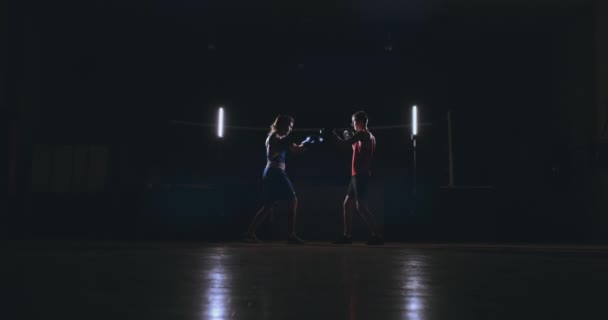 Жінка удари тренажерний зал боксу, мітенки фокус — стокове відео