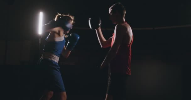 Mujer joven adulta haciendo entrenamiento de kickboxing con su entrenador . — Vídeos de Stock