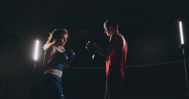 Kickboxer mulher atleta kickboxing treinador formação feminino fitness amigos boxe perfuração foco mitts desfrutar de exercício intenso treino em conjunto no ginásio de perto — Vídeo de Stock