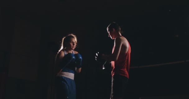 Jovem mulher adulta fazendo treinamento de kickboxing com seu treinador . — Vídeo de Stock