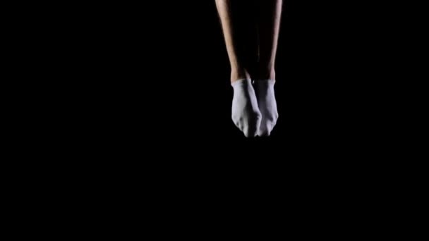 一位穿着白色衣服的英俊男体操运动员在黑色背景下慢动作、旋转和翻转表演杂技特技。飞行和自由的感觉. — 图库视频影像
