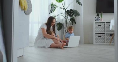 İki çocuklu genç bir ilerici anne babasına video iletişimi ile konuşuyor. Modern teknoloji genç bir ailedir.