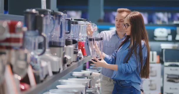 Young couple man and woman in appliances store selects a blender for their cuisine — Stock Video