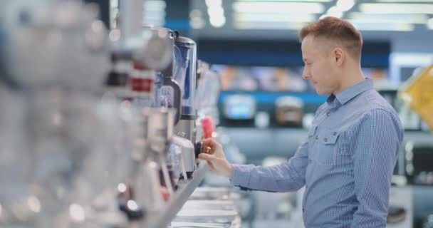 가전 제품 상점에서 주방 기술자는 자신의 손에 블렌더를 선택 하 고 디자인과 특성을 고려. — 비디오
