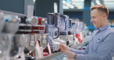 Aletler deposunda, mutfak teknisyeni elinde blender seçer ve tasarım ve özellikleri dikkate.