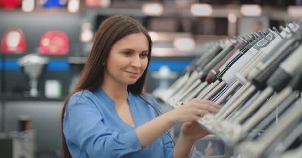 Joven hermosa morena sexy elige una licuadora para la cocina en la tienda de electrodomésticos — Vídeo de stock