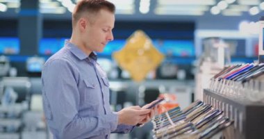 Yeni akıllı telefon çalışan adam. Teknoloji Mağazası iç.