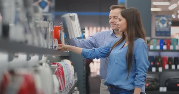 행복한 남자와 여자는 하드웨어 및 전자 제품 상점에서 자신의 가정을위한 전기 티 트리를 선택 — 비디오