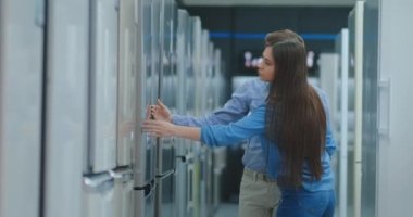 Bir erkek ve bir kadın yeni bir ev satın almak için bir buzdolabı seçin