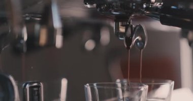 Kahve makinesinden dökülen espressonun yakın çekimi. Profesyonel kahve demleme. Bir kafelatte kahve yapma.