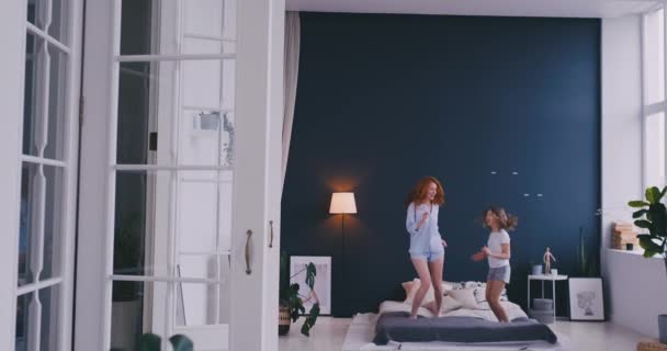 Мать и дочь прыгают на кровати, счастье, радость — стоковое видео