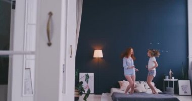 Küçük kız onun sevgi dolu bir anne ile iyi eğlenceler televizyonda gösteri dans dans modern tarzı birlikte izlerken öğrenme ve yatağa evde sabah sırasında atlama