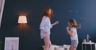 Küçük kız onun sevgi dolu bir anne ile iyi eğlenceler televizyonda gösteri dans dans modern tarzı birlikte izlerken öğrenme ve yatağa evde sabah sırasında atlama
