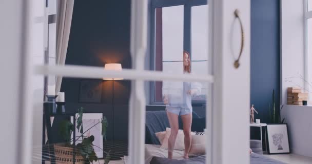Zabawny dziewczynka z matką miłości zabawy nauka tańca nowoczesnego stylu razem oglądając pokaz tańca na Tv i skoki na łóżku podczas rano w domu — Wideo stockowe